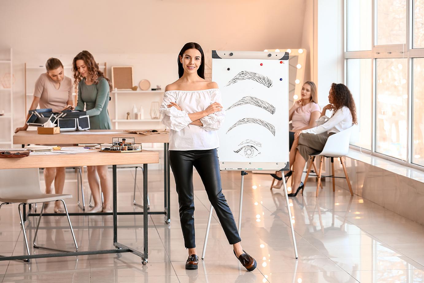 Image of a woman smiling with people working in the background